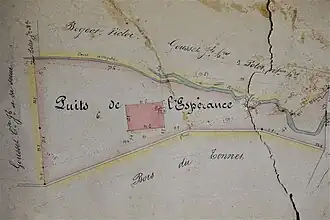 Plan de masse montrant la parcelle en rouge et le puits en noir.