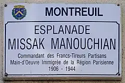 Photographie du panneau de l'esplanade Missak Manouchian de Montreuil disant « Commandant des Francs-Tireurs Partisans Main d'Œuvre Immigrée de la Région Parisienne 1906-1944 ».