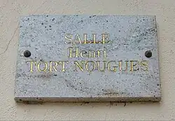 Plaque portant le nom d'Henri Tort-Nouguès visible sur le foyer municipal.