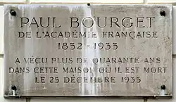Plaque de marbre fixée sur un mur rappelant le souvenir de Paul Bourget.
