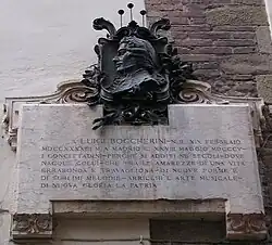 photo : plaque commémorative en marbre surmontée d'un relief de bronze avec le profil d'une tête d'homme.