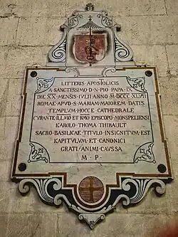 Plaque commémorative de l'érection comme basilique mineure par le pape Pie IX (20 juillet 1847), surmontée des armoiries du chapitre.