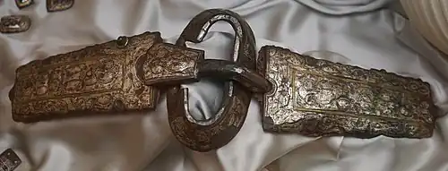 Photographie d'une plaque et d'une boucle de ceinture retrouvée dans la sépulture féminine no 590, et actuellement conservée au Musée Saint-Loup, à Troyes.