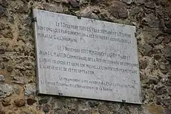 Plaque commémorative fixée sur un mur.