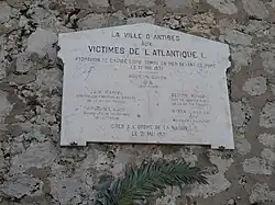 Plaque de marbre, portant l’inscription : "La ville d’Antibes aux victimes de l’Atlantique I, hydravion de grande ligne tombé en mer devant ce port le 19 mai 1937. Bourdin Lucien (chef pilote), Juin Marcel (contrôleur direction du matériel de la compagnie Air France), Brochet Luce (second-maître mécanicien de la Marine), Blouin Robert (chef de service radio de la compagnie Air France), Rayer Charles (mécanicien naviguant), Cités à l’Ordre de la nation le 21 mai 1937"