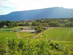 Vue depuis la colline du bourg sur le terrain sportif en contre-bas