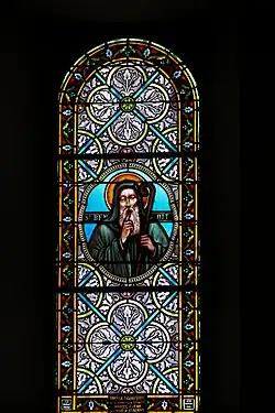 Photographie couleur d'un vitrail montrant saint Benoît en médaillon.