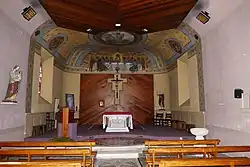 Photographie couleur de l'intérieur d'une église à nef unique de petites dimensions.