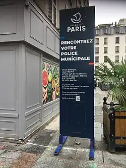Totem bleu portant des inscriptions invitant à rencontrer la police municipale à heures fixes.