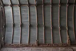 Photographie d'une voûte lambrissée avec sablières sculptées