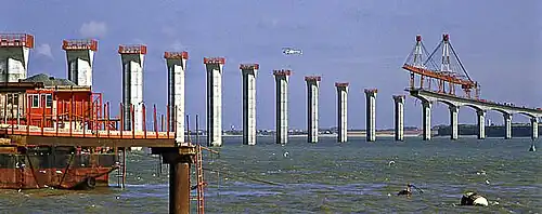 Construction du pont. La poutre de lancement de manipulation des voussoirs mesurait 285 m de long. Elle fut démontée sur l'île à la fin des travaux.
