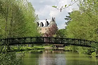 Photographie en couleurs d'une passerelle métallique enjambant un cours d'eau.