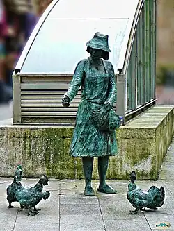 Femme avec des poules, en face du marché central.