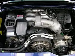 Compartiment moteur d'une 911 équipée du moteur de 285&nbsp;ch, le collecteur d'admission en acier est visible sur la partie haute du moteur.
