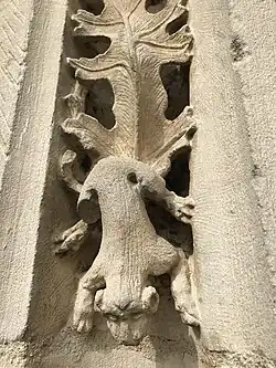 Sculpture d'un petit chien descendant d'une feuille de vigne.