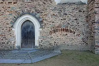 Porte de la chapelle et arc du XIIIe&nbsp;siècle.