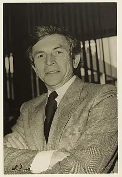 Photo en noir et blanc de Jean Normand, premier président de la SEMTCAR, posant souriant et bras croisés.