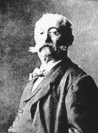 Portrait photographique en couleurs d'un homme en plan taille, tête tournée vers l'ojectif.