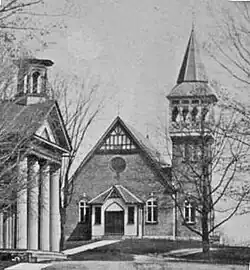 Un bâtiment à colombages avec une toiture à pignon et un clocher.