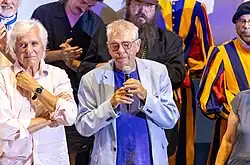 Le réalisateur André Forcier parlant au micro et entouré d'artisans et acteurs du film après la projection de la première mondiale à Montréal.