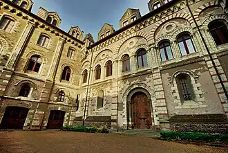  Photographie d'un presbytère médiéval en tuffeau, façade sur cour.
