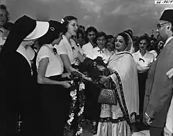 photo d'un homme et d'une femme saluant des jeunes femmes alignées