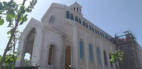 Façades principale et droite d'une église inachevée.