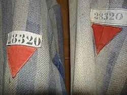 Red emblems of a political enemy on a Dachau detainee's clothing.