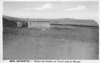 Vestige du puits entouré d'un mur après la démolition des bâtiments.