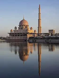 Un grand bâtiment ouvragé surmonté d'un dôme avec à côté une fine tour.