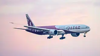 Une livrée de partenariat d'un Boeing 777-3DZ(ER) de Qatar Airways en phase d'atterrissage.