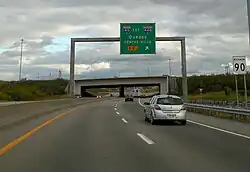 Une voie rapide avec une supersignalisation et un panneau de limite de vitesse.
