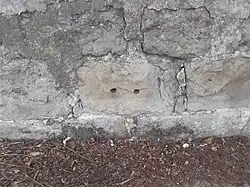 Andrézieux, remploi d'un dé en pierre, support de rail, dans un mur.