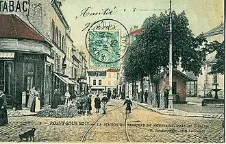 Paysage du centre ville vers 1905. La station du tramway Nogentais et ses rails, implantés au plein milieu de la rue, peut être aperçue.