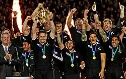 Photographie de plusieurs personnes célébrant une victoire lors d'un événement sportif.