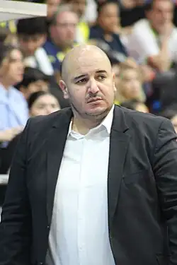 Homme en costume debout.