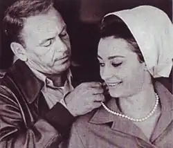 Frank Sinatra à gauche mettant un collier à Raffaella Carrà sur la droite de l'image pendant le tournage du film