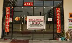 Two glass doors with a "notice of closure" sign affixed to them