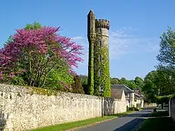 La tour haute de 30 m ; derrière, l'orangerie puis l'ancienne écurie du château sont visibles.