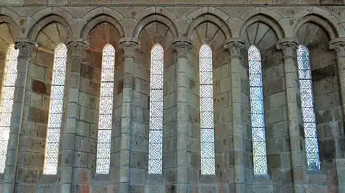 Détail des fenêtres aussi étroites que des meurtrières, couronnées d'arcs couverts de voûtelettes d'ogives.