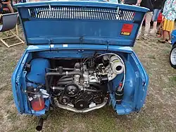 Le capot d'une voiture bleue ouvert sur un moteur en position arrière.