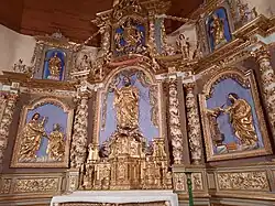 Photographie en couleurs, représentant un retable dans une église.