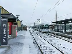 La station de Meyzieu Z.I. est à quatre voies. Les deux voies les plus au sud sont masquées par la rame Citadis du T3 qui quitte son terminus.