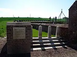 Le cimetière militaire britannique est derrière le cimetière communal, avec un accès sur la gauche de celui-ci.