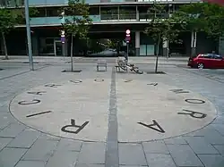 Photographie du sol d'une place de Barcelone avec un grand cercle et le nom de Ricardo Zamora sur le bord de celui-ci.