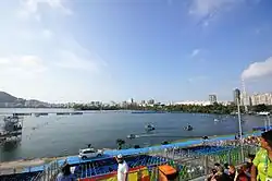 Photographie du Lagoa Rodrigo de Freitas lors des compétitions de canoë-kayak. Au premier plan, des gradins, à l'arrière-plan, la ville de Rio de Janeiro et ses immeubles.