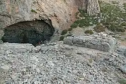 Entrée d'une caverne s'ouvrant au flanc d'une montagne rocailleuse