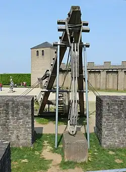 Machine de levage de pierres avec à l'arrière-plan des murailles