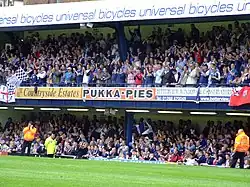 Un stand du Roots Hall, le stade de Southend United, pendant un match et rempli de supporters.