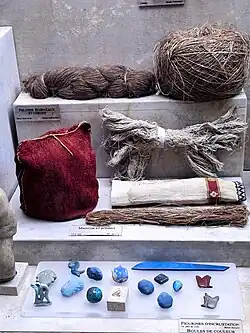 Pelote, écheveau et cordes, lin. Manche et bonnet : lin et laine, tissé, brodé. Figurines d’incrustation. Boules de couleur